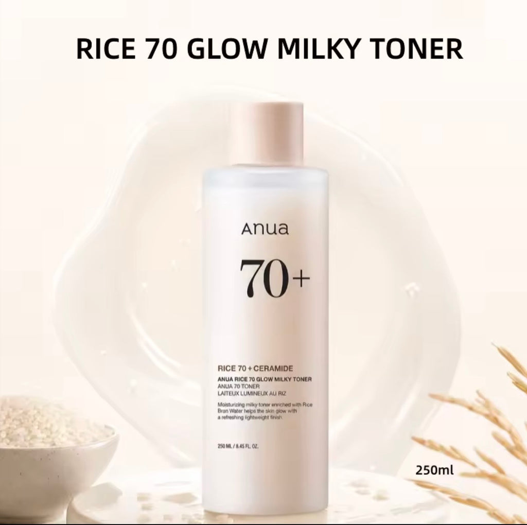 Anua Rice 70 Glow Milky Toner bottle, 250ml, shown against a warm cream background with decorative dried flowers and a bowl of rice.