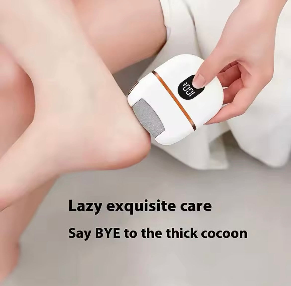 A close-up of a person using an electric foot file on their foot, with overlaid text reading 'Lazy exquisite care Say BYE to the thick cocoon.' The product is a compact white foot file with a gray abrasive pad and a small black digital display.