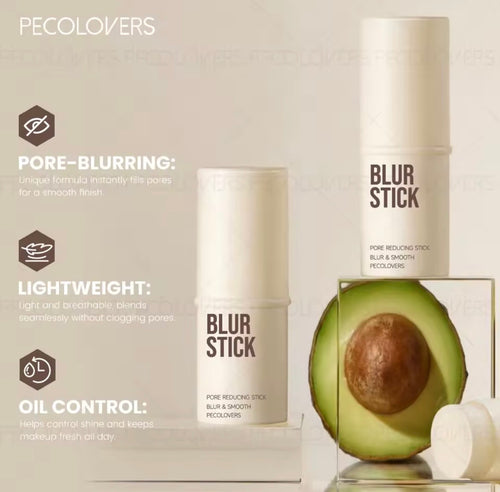 Pecolovers Blur Stick pore-reducing stick shown in a clean studio composition with two white cylindrical containers, one standing upright and one lying down on a clear acrylic block. A cut avocado is placed beside the products as a styling prop.