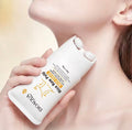 A close-up lifestyle shot of a woman holding a white Bioaqua Rice Raw Pulp hair growth shampoo bottle against her neck and shoulder, with a soft, warm beige background.