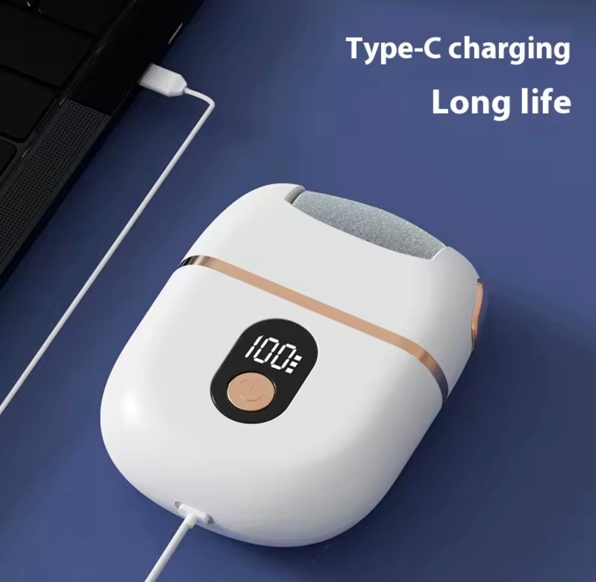 A white portable wireless earbuds charging case with a digital display showing 100% battery and a rose gold accent stripe, shown on a blue desk next to a laptop with a white cable plugged in. Text on the image reads 'Type-C charging Long life'.